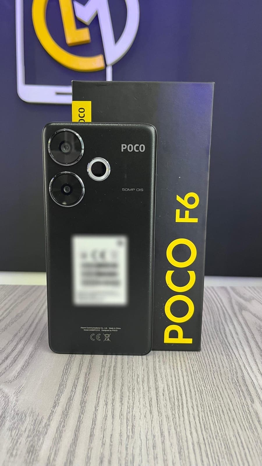Dorso del POCO F6 negro junto a su caja en el local de LM Tecnología